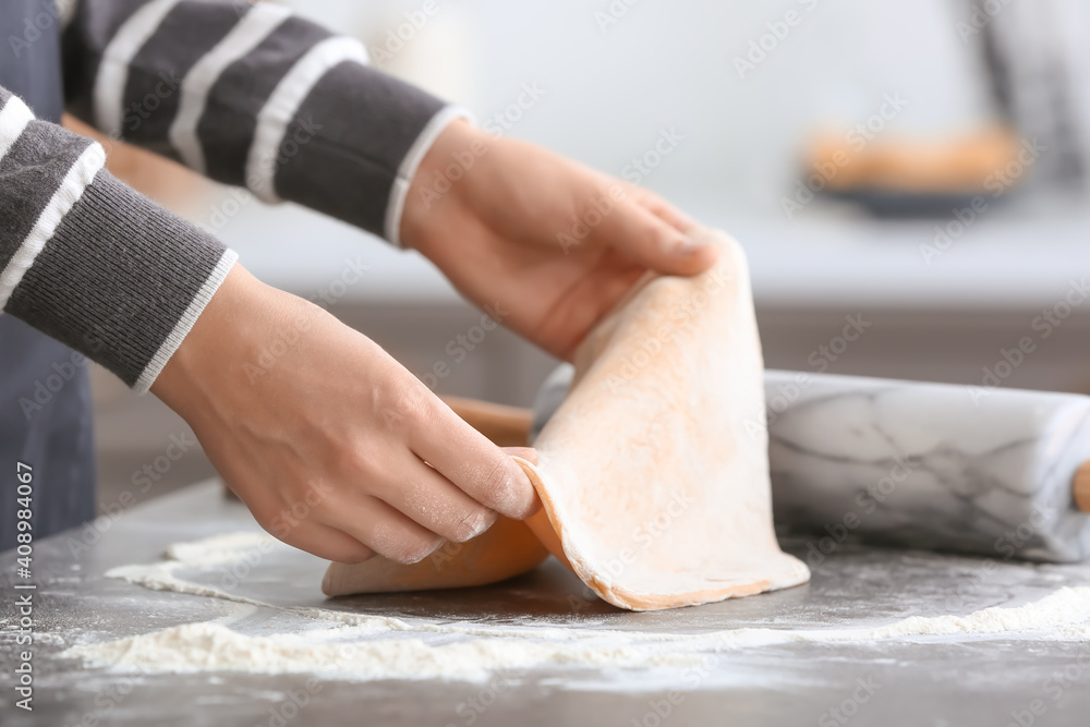 Woman making dough in kitchen