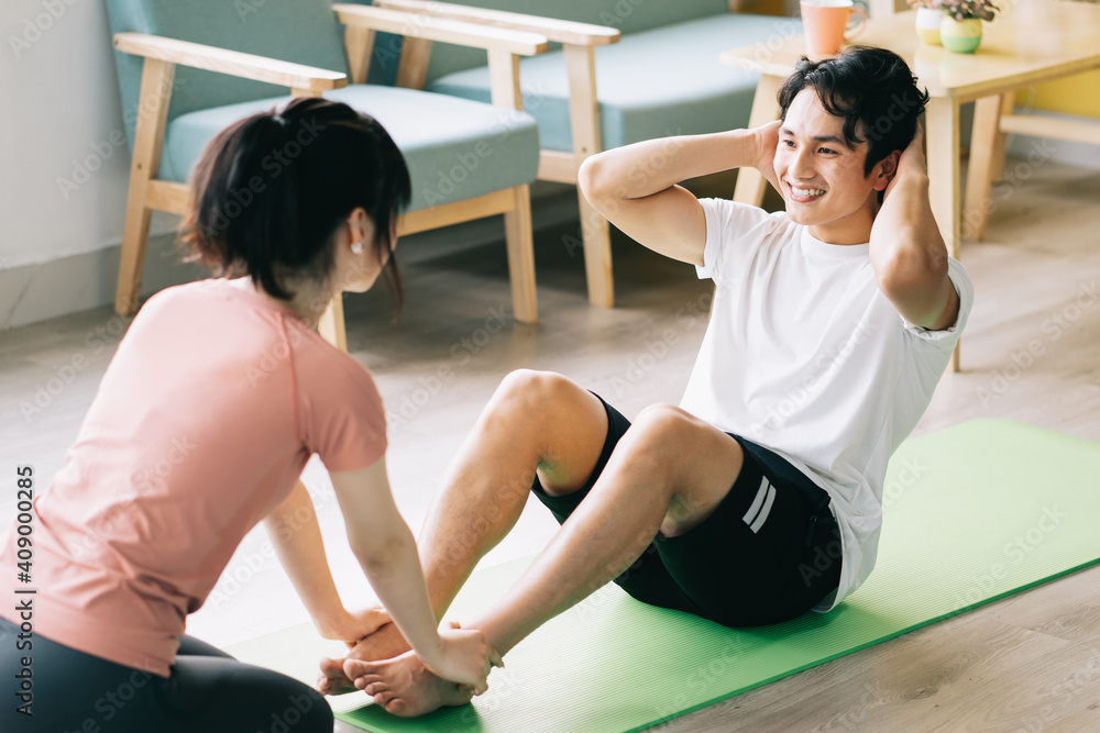 亚洲女孩抱着男友的脚做仰卧起坐