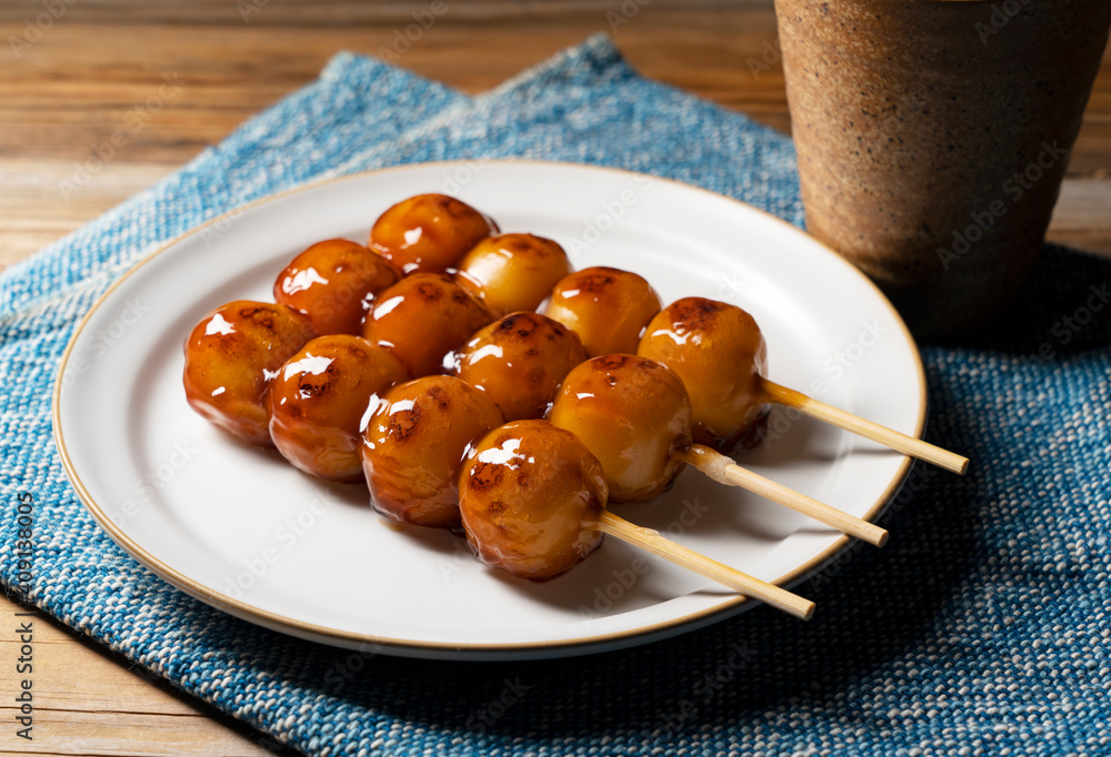 Mitarashi dango and green tea on a wooden background