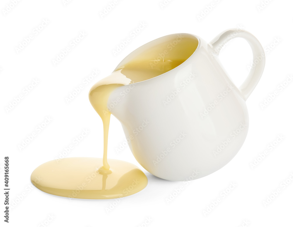 Jug with sweet condensed milk on white background