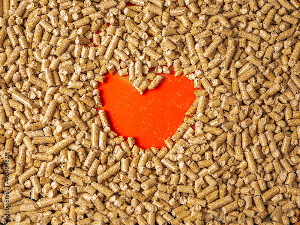 Natural wooden pellets background and empty hole as red heart. Close-up wood pellet pattern. Flat la