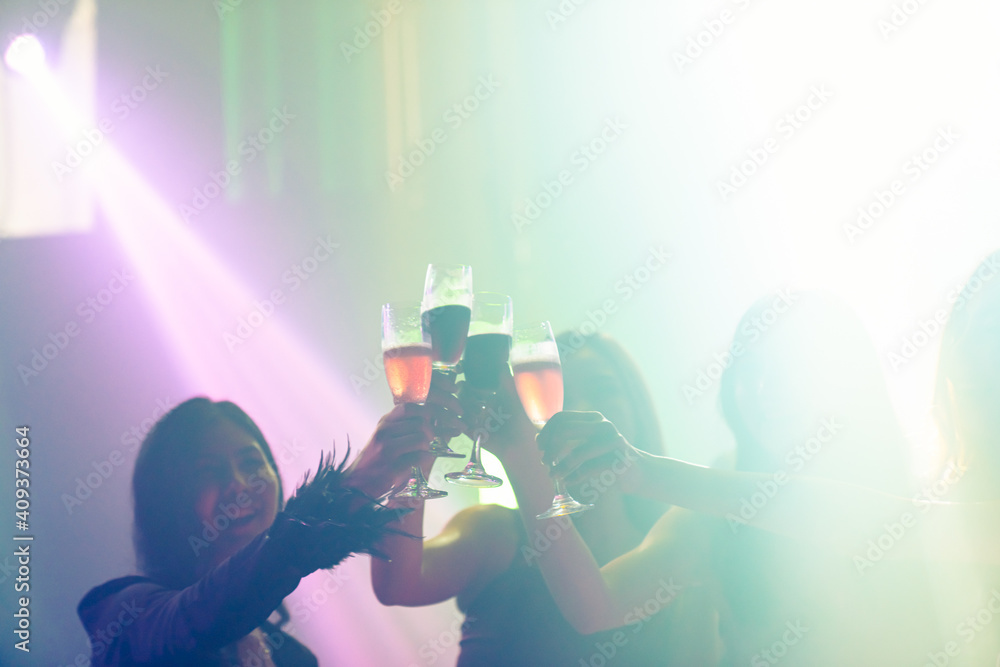 Silhouette image of people dance in disco night club to music from DJ on stage . New year night part