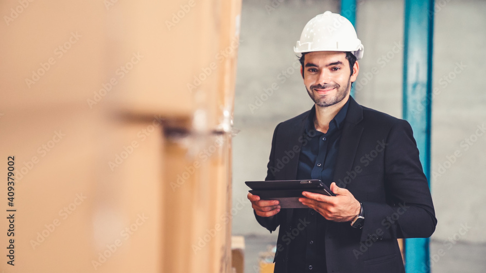 Factory manager using tablet computer in warehouse or factory . Industry and supply chain management