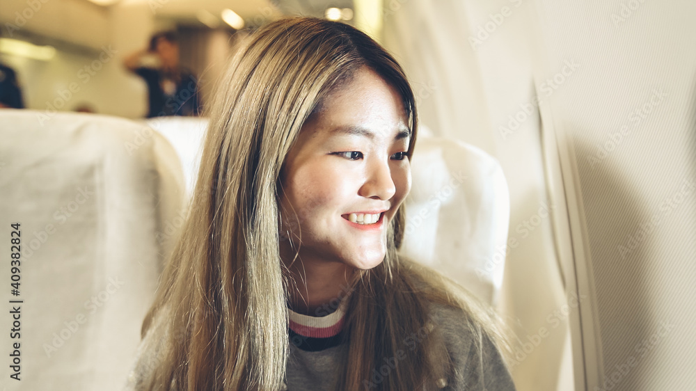 Happy asian woman travel in airplane for vacation tourism .