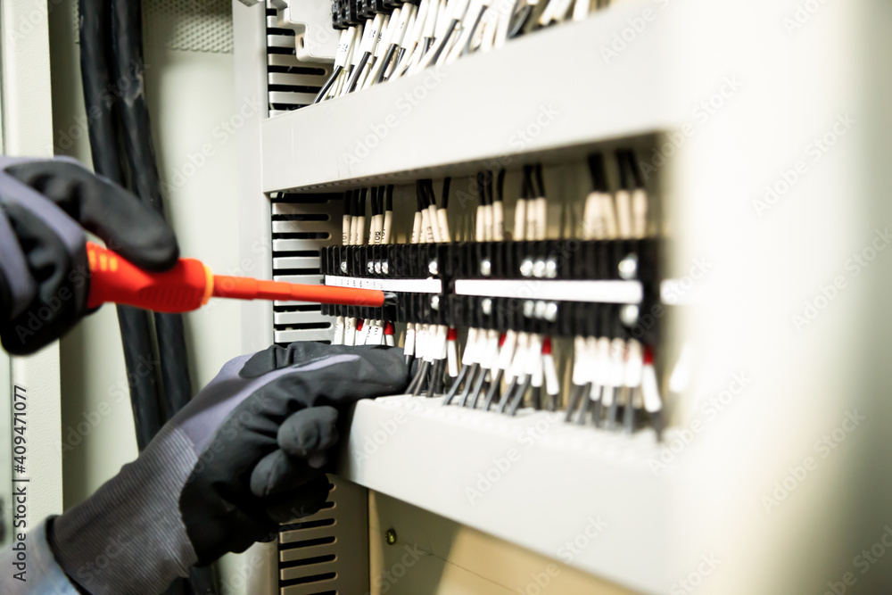 Electricians work to connect electric wires in the system, switchboard, electrical system in Control