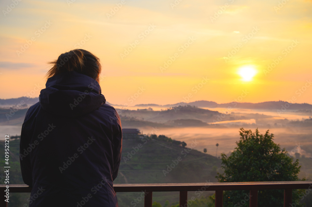 Asian woman enjoys the view of misty landscape in morning at Khao Kho hill in Phetchabun, Thailand