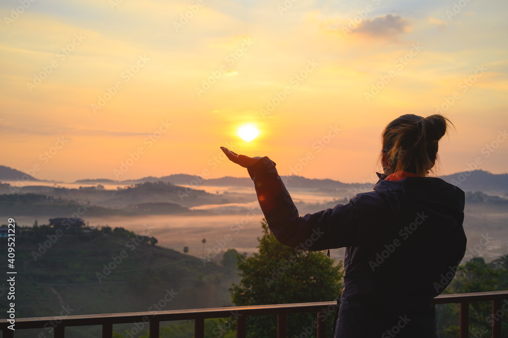 Asian woman enjoys the view of misty landscape in morning at Khao Kho hill in Phetchabun, Thailand