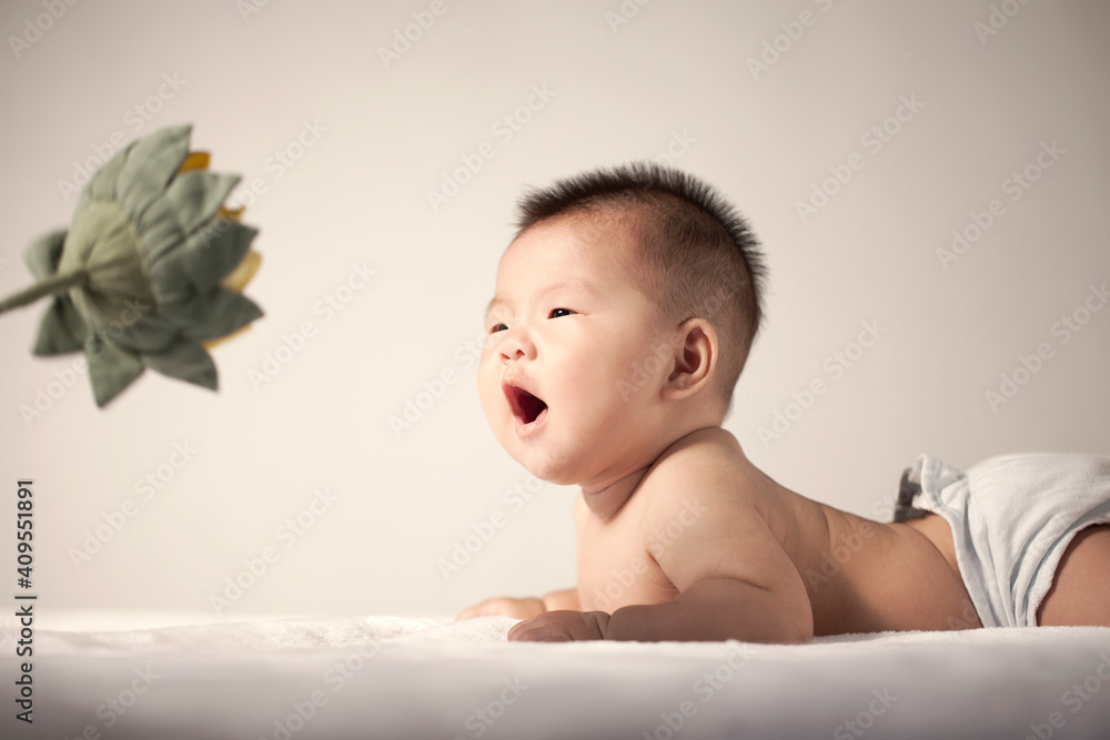 A baby looking at a sunflower