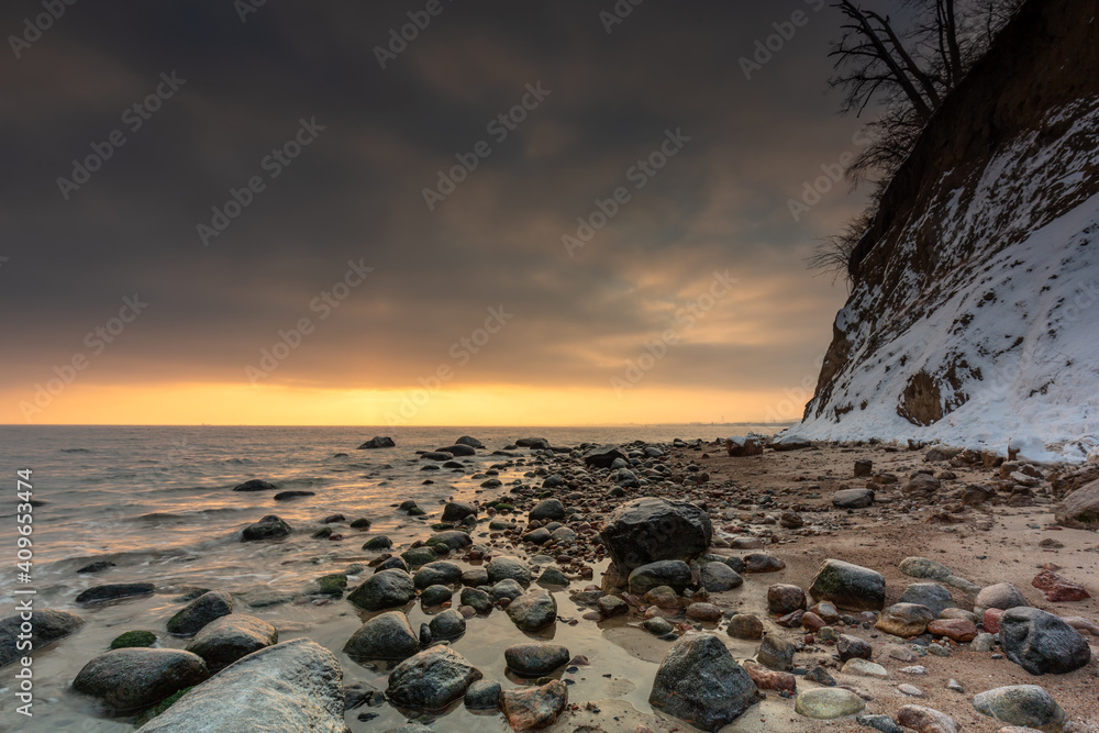 日出时Gdynia Orlowo海滩上冰冻岩石的惊人景观。波兰