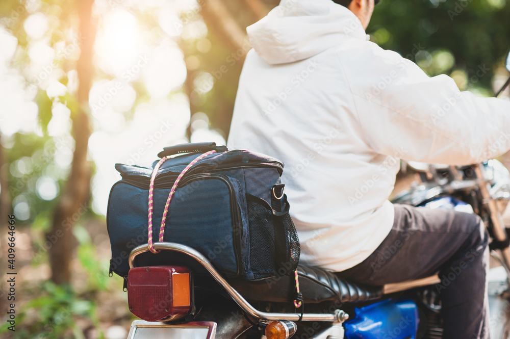 Young male tourists driving motorcycles and carrying luggage.