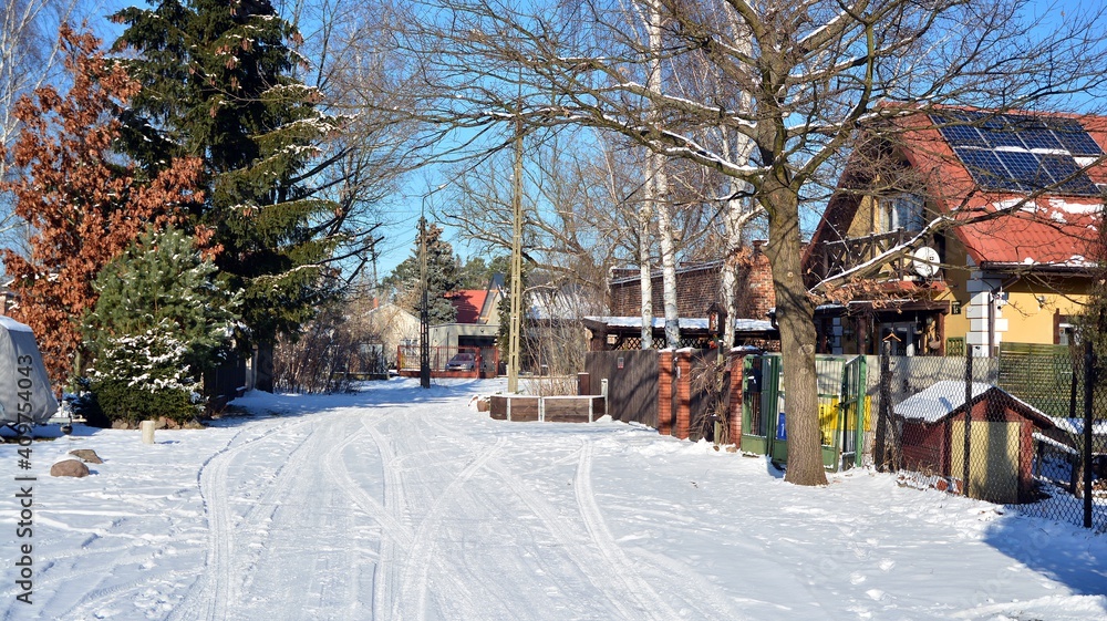 Residential neighborhood in the suburbs during a white snow storm and roads covered in snow. 