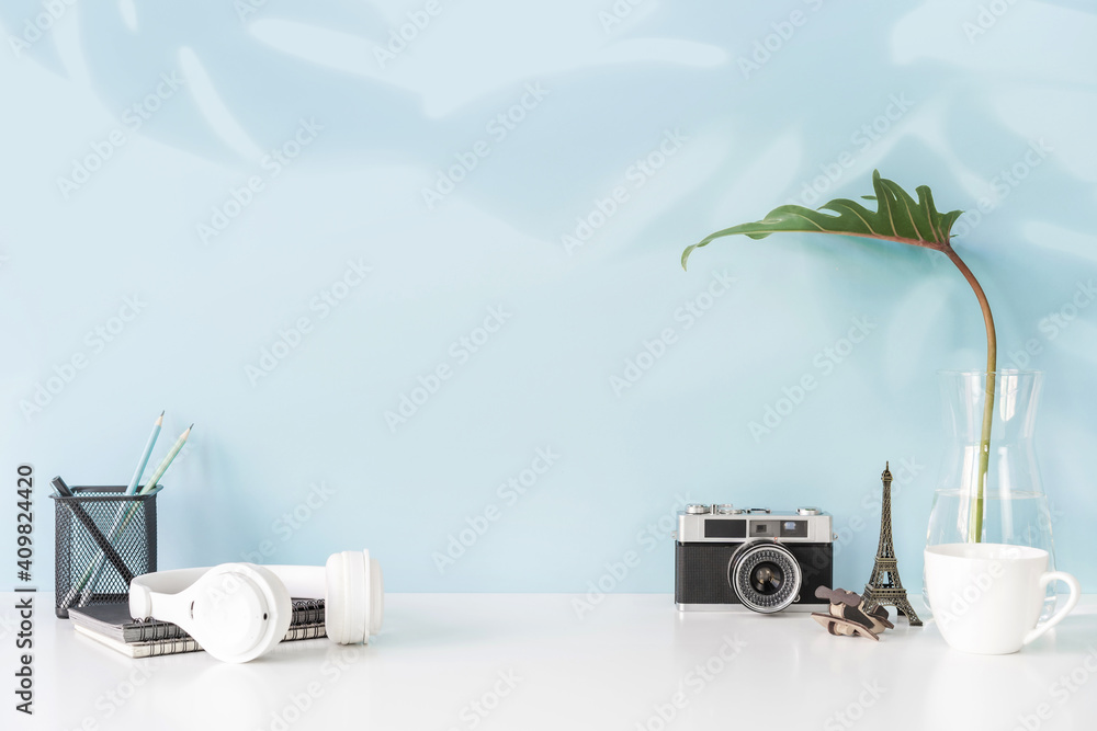 Modern and stylish workspace with office supplies and retro camera with color background and copy sp