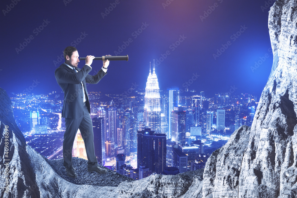 Businessman on cliff looking into distance