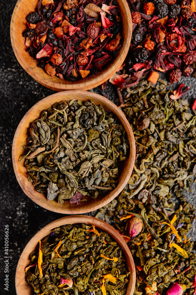 Wooden bowls with different sorts of dry tea leaves