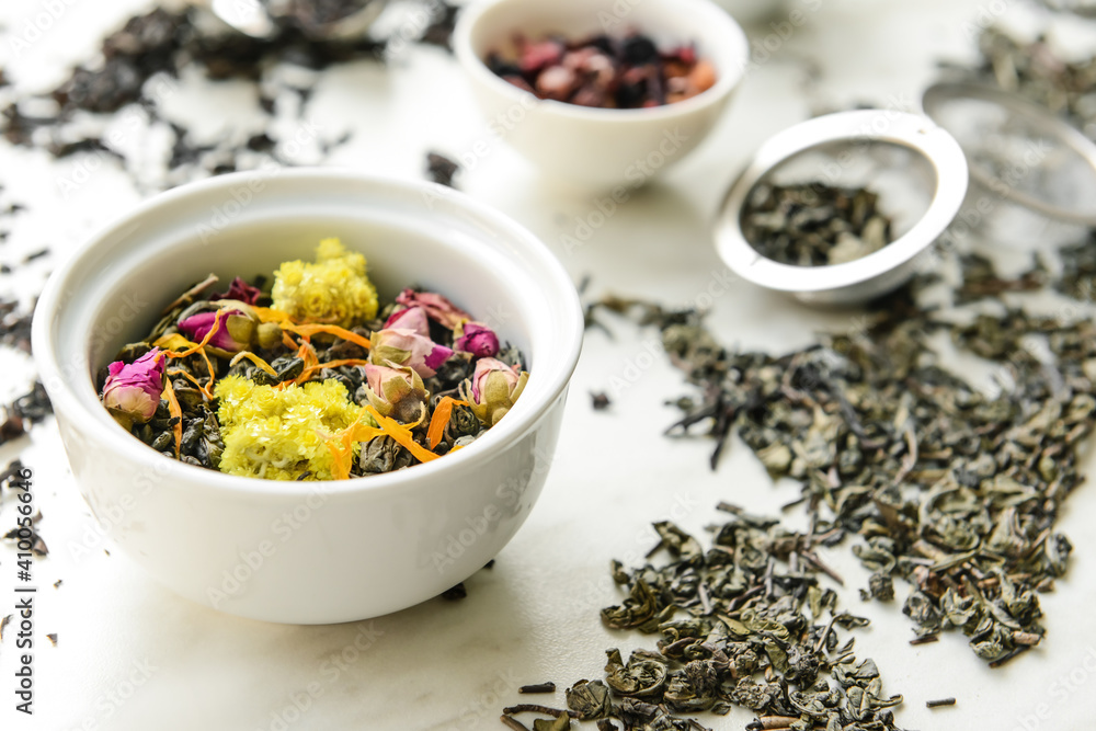 Bowls with different sorts of dry tea leaves on table