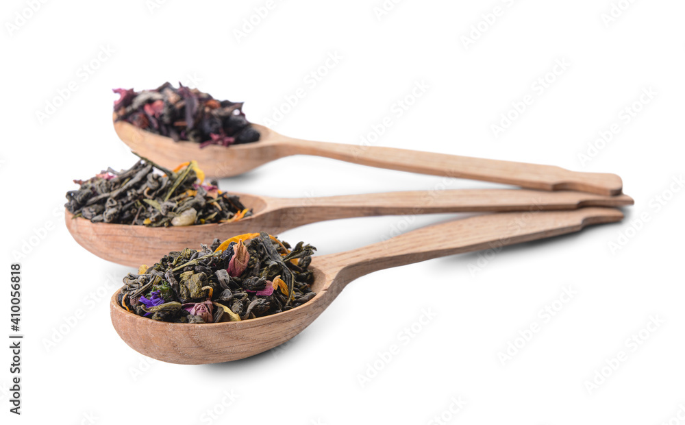 Wooden spoons with dry tea leaves and flowers on white background