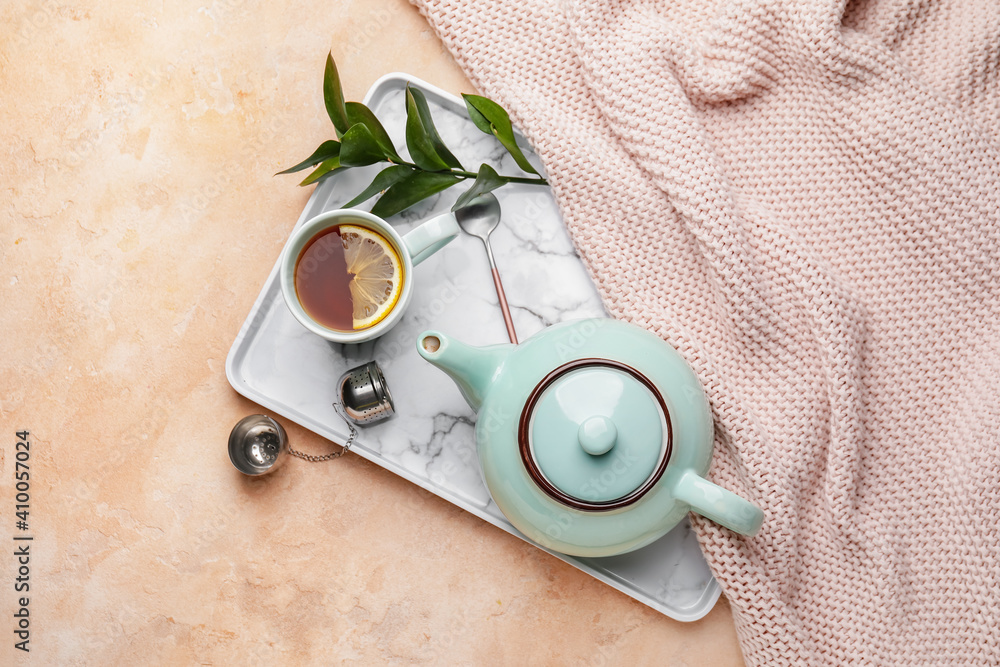 Composition with teapot and cup of tea on color background