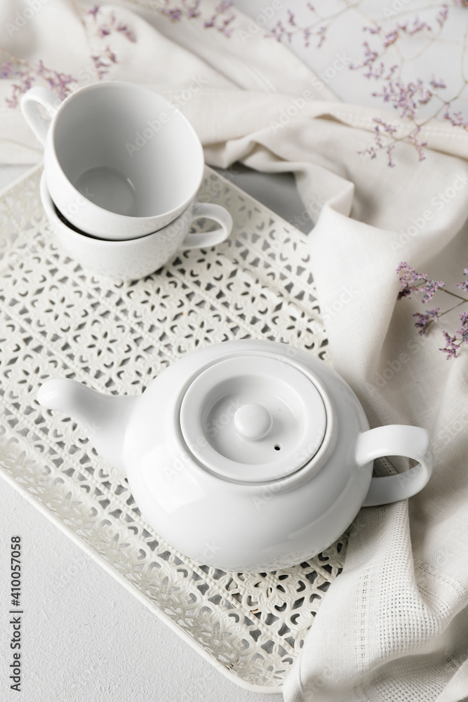 Teapot and cups on light background