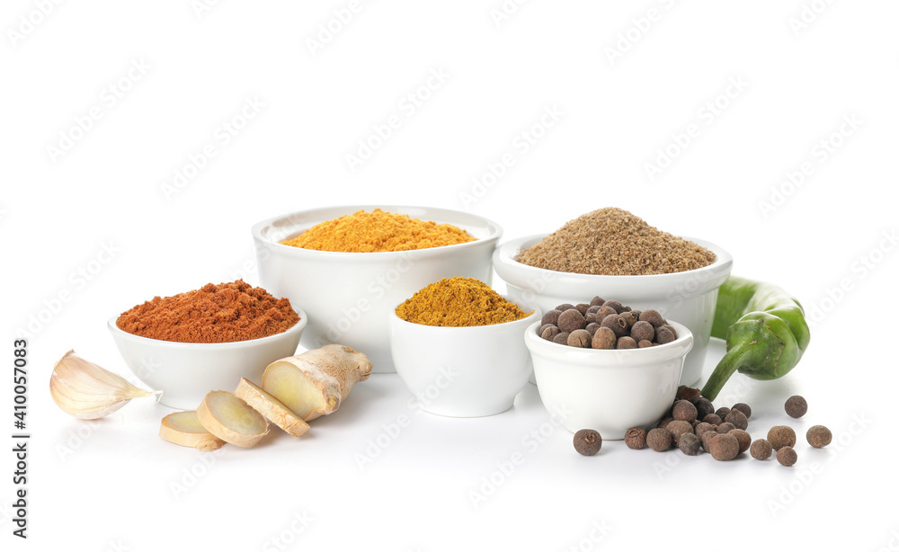 Bowls with different spices on white background