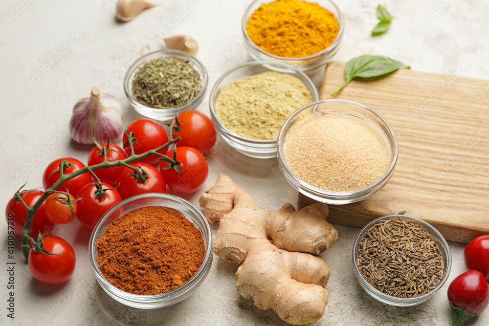 Composition with different spices and tomatoes on light background