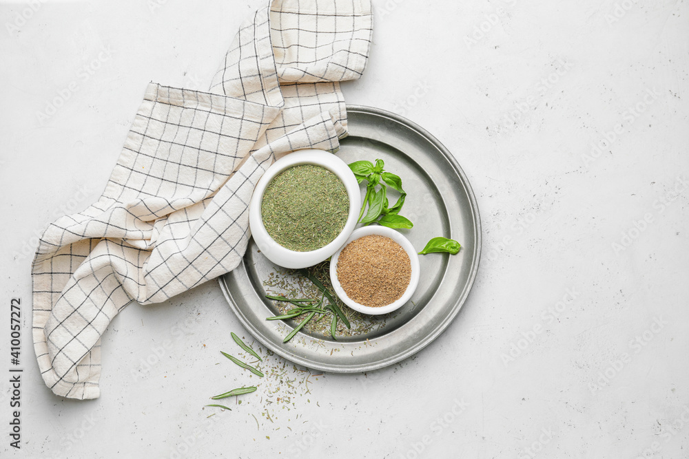 Tray with different spices and herbs on light background