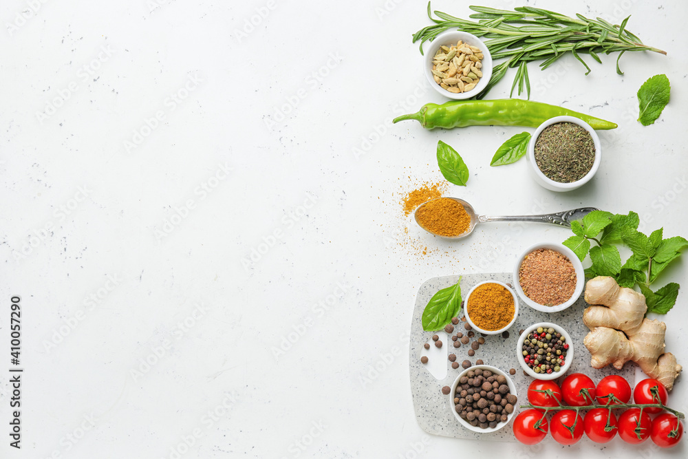 Composition with different spices and herbs on light background