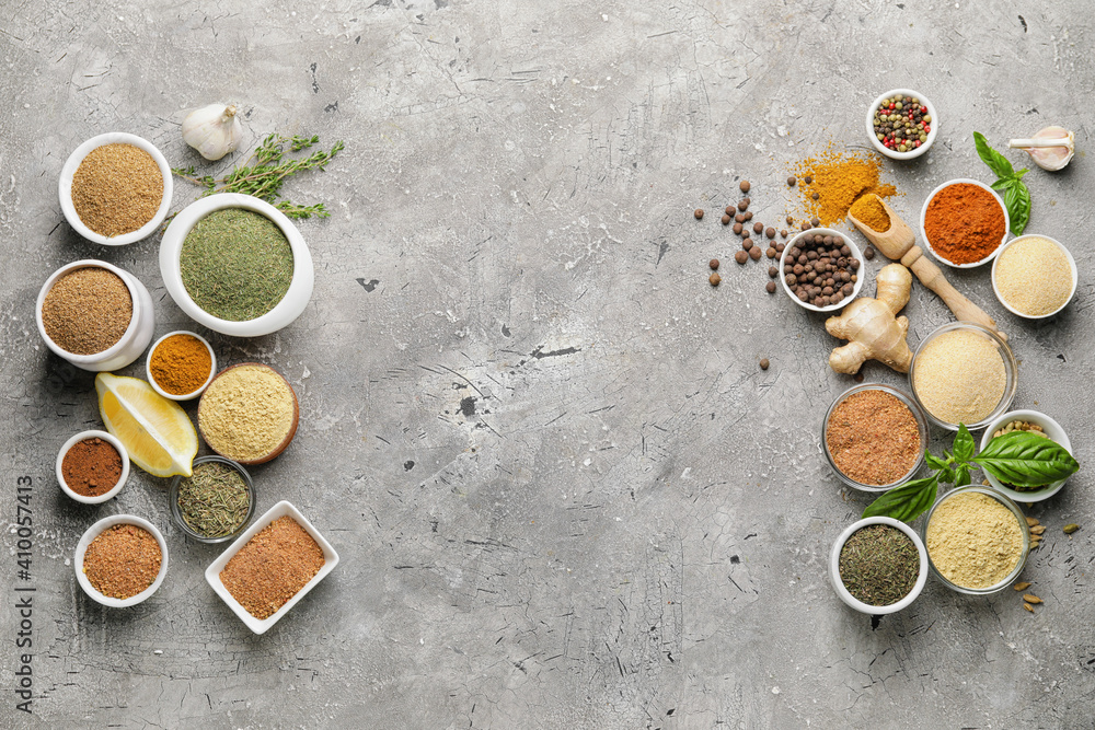 Composition with different spices and herbs on grey background