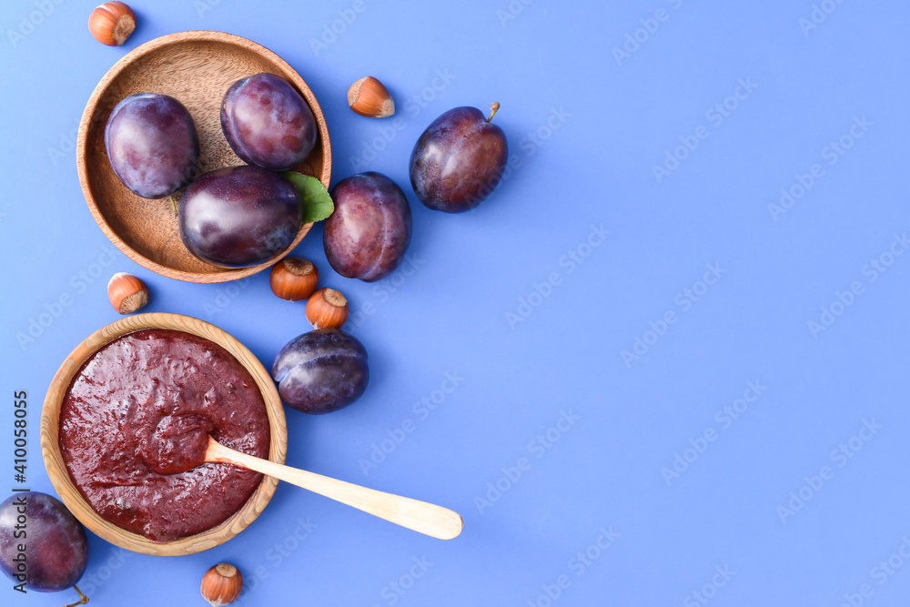 Bowl with delicious homemade plum jam on color background