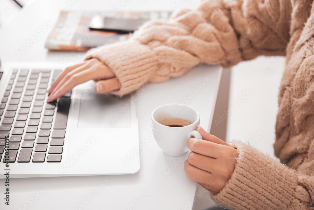 Beautiful woman with laptop and cup of hot espresso in cafe