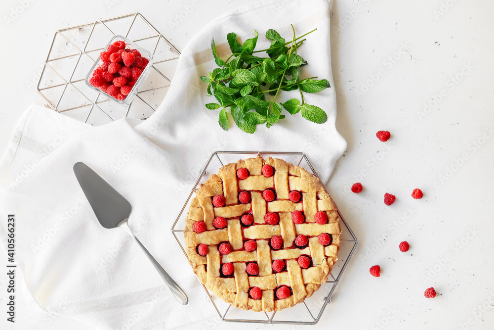 Stand with tasty raspberry pie on light table