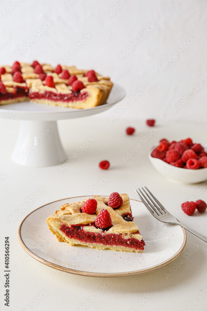 Piece of yummy raspberry pie on light background