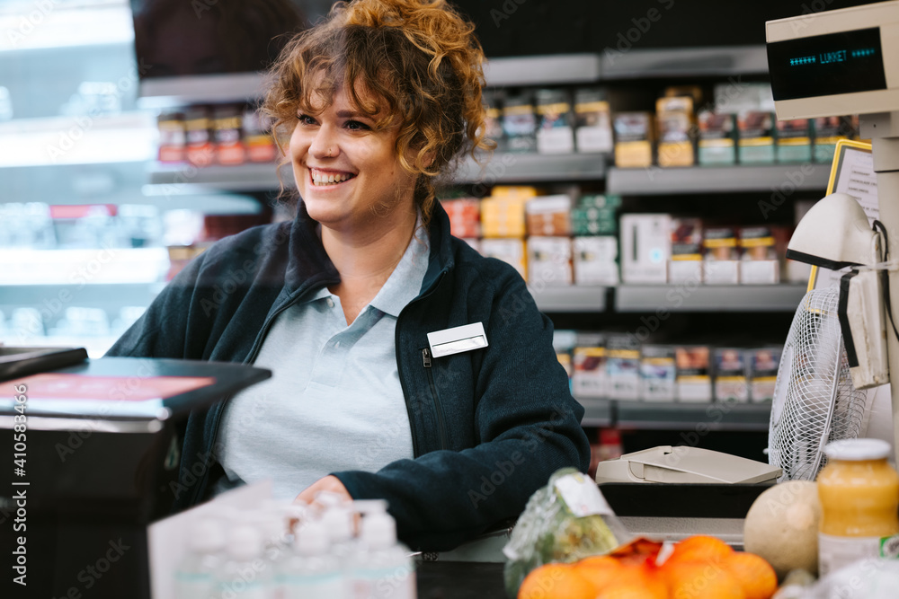 Supermarket cashier attending customer