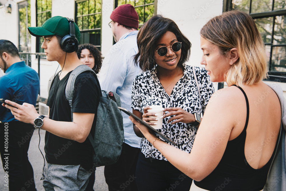 Happy women discussing at a workshop using a digital tablet