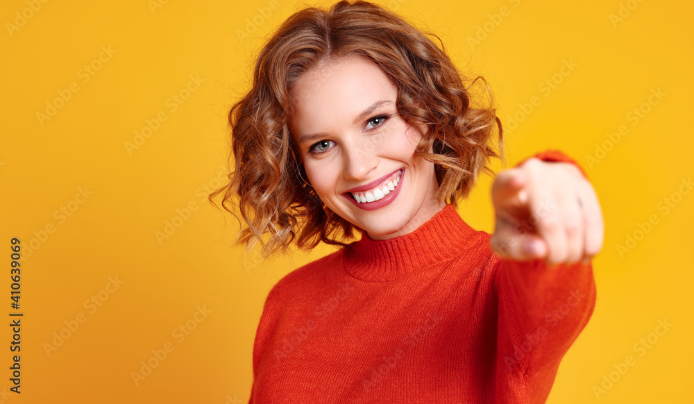 Friendly young female pointing at camera