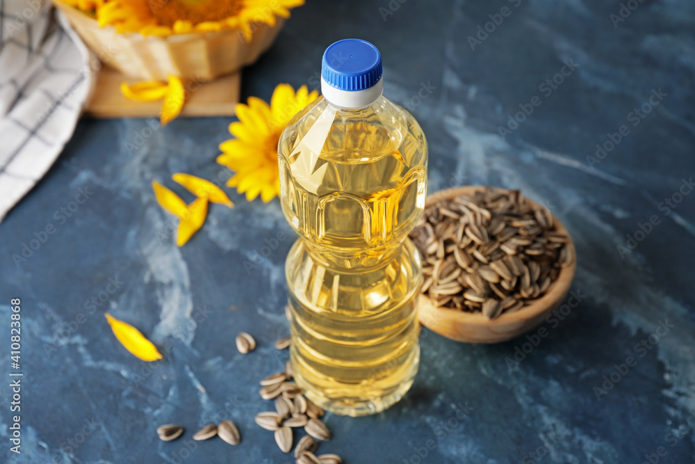 Plastic bottle of sunflower oil on color background