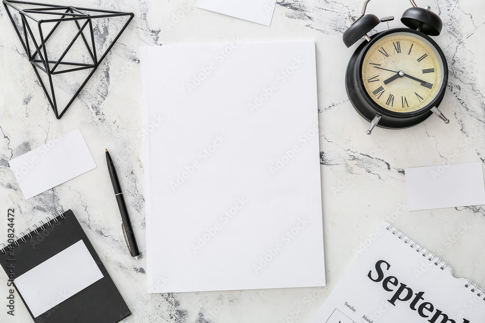 Blank magazine, alarm clock and pen on light background