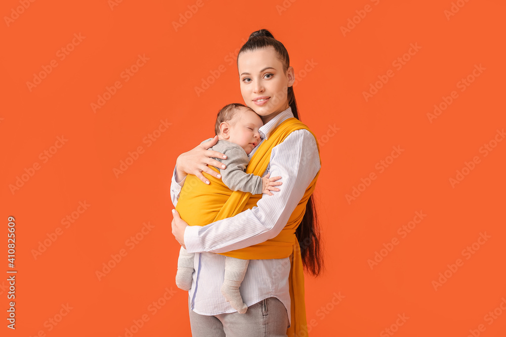 Young mother with little baby in sling on color background