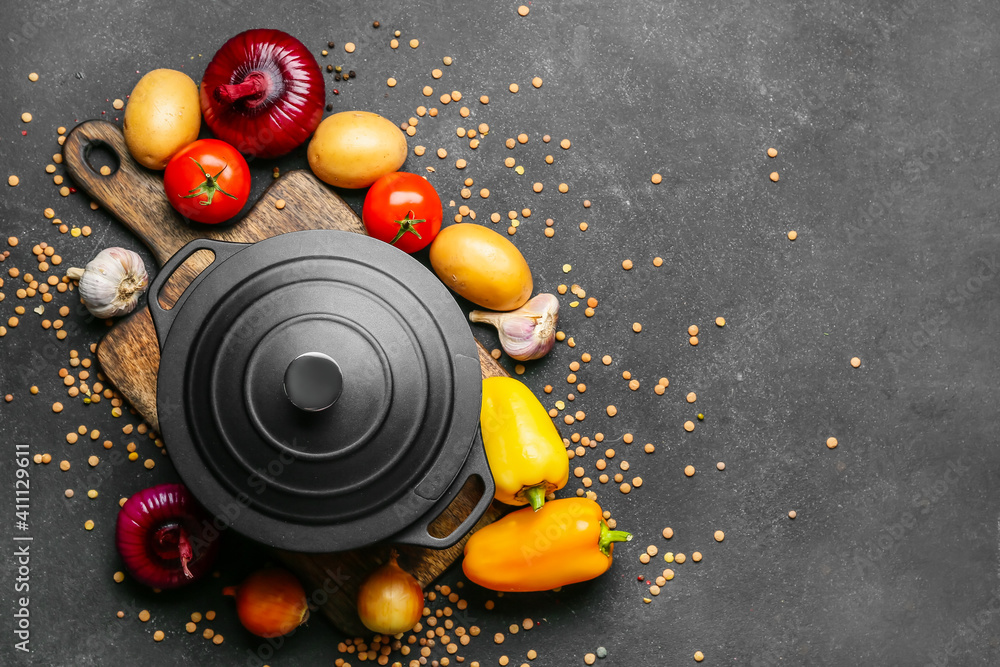 Vegetables and cooking pot on dark background