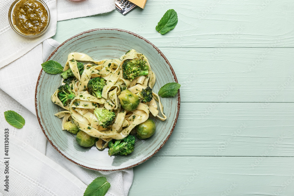 Tasty pasta with broccoli and Brussels sprouts on color wooden background