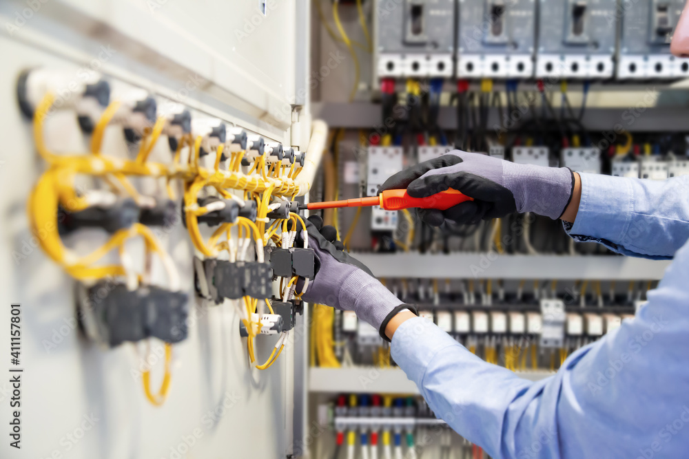 Electricians work to connect electric wires in the system, switchboard, electrical system in Control