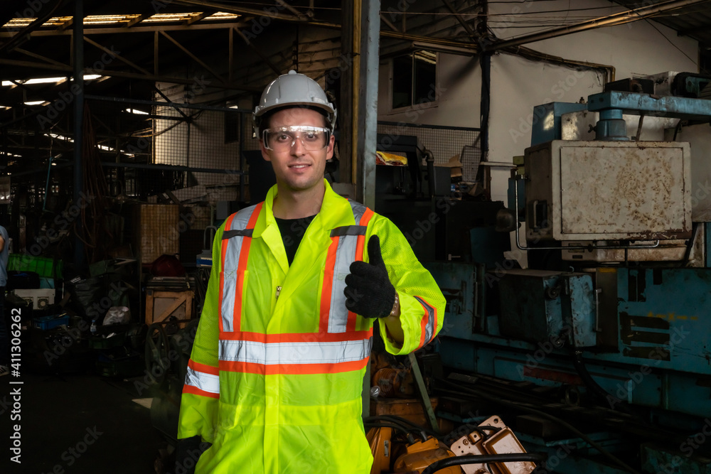 Young skillful factory worker or engineer close up portrait in factory . Industry and engineering co