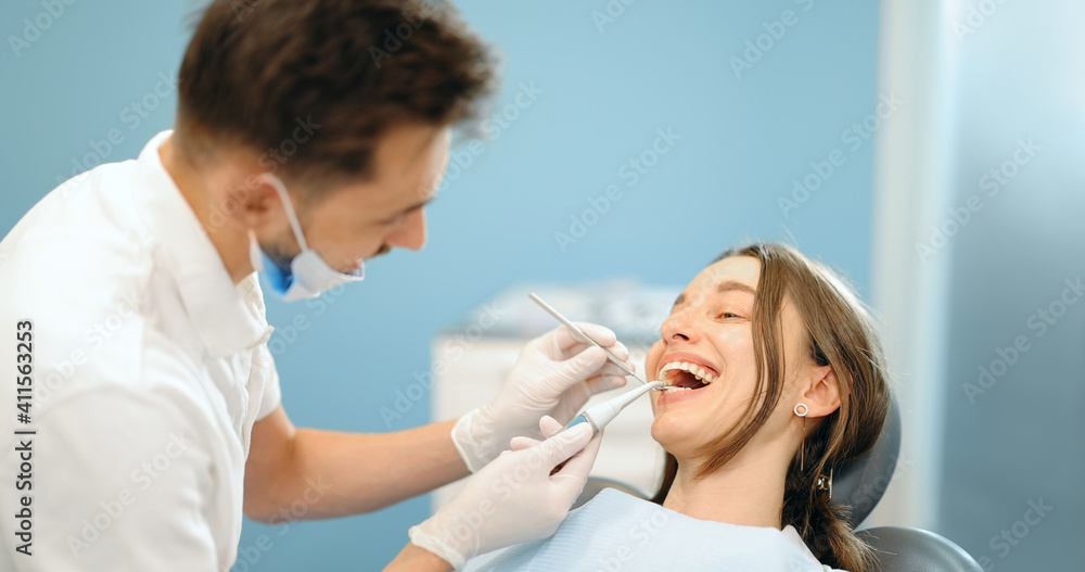 Young patient during a dental checkup. Dentist examining teeth of a woman at the dental office. 4k v