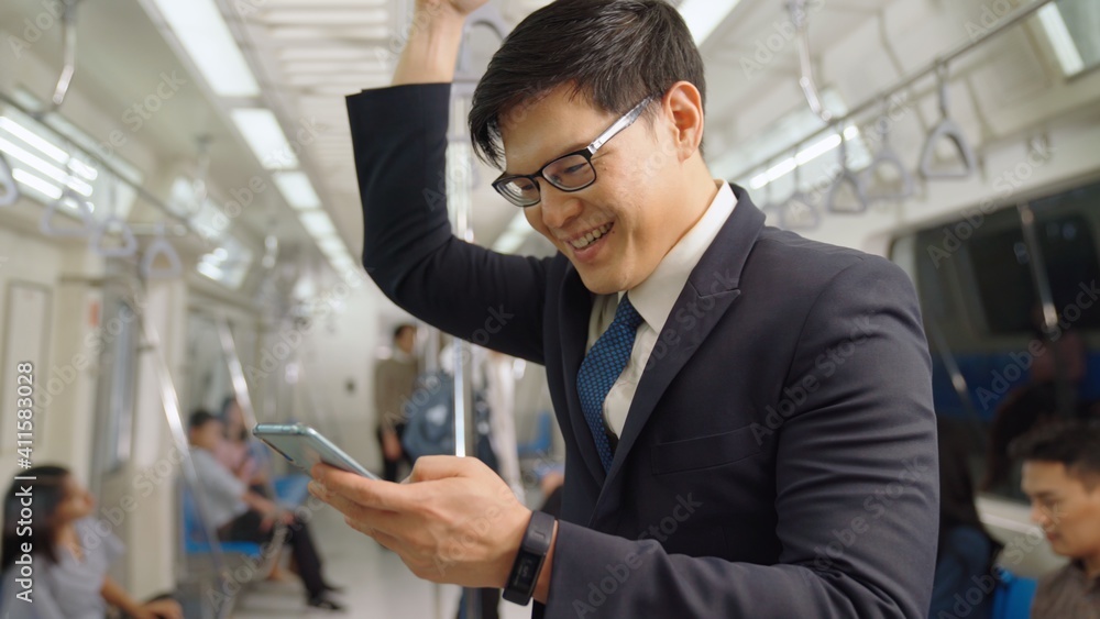 Businessman using mobile phone on public train . Urban city lifestyle commuting concept .