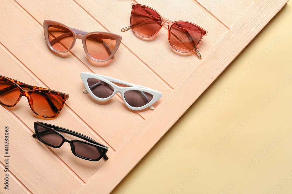 Stylish sunglasses on color background