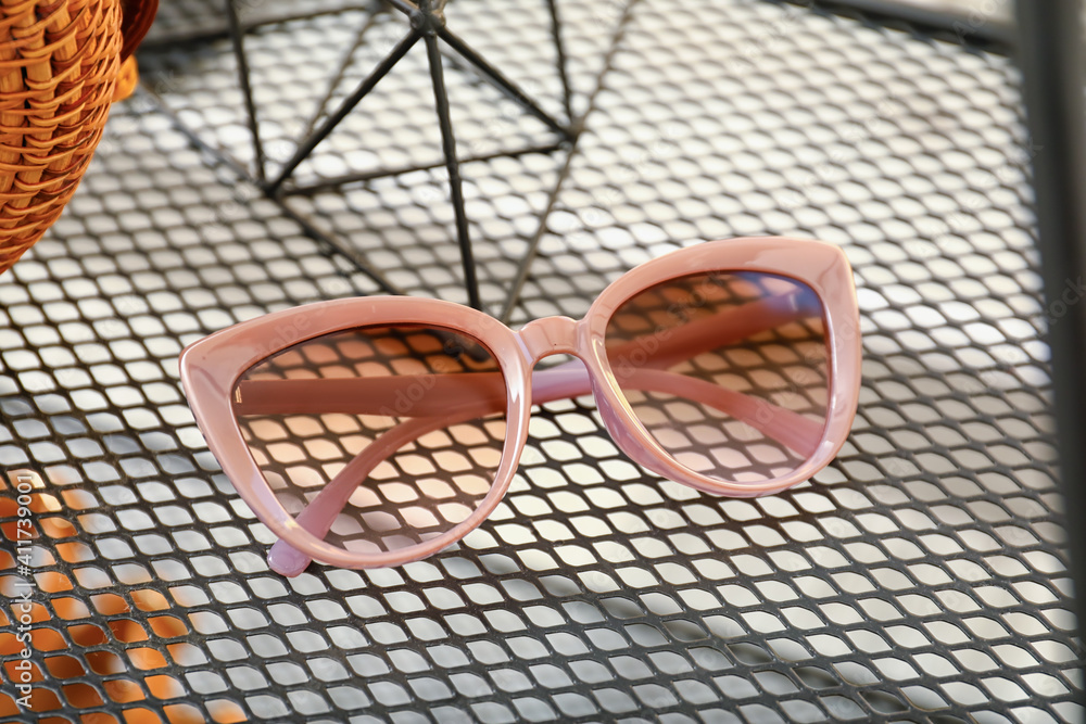 Stylish female sunglasses on shelf