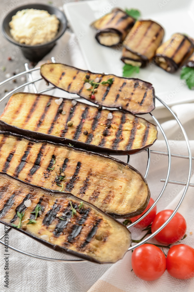 Cooling rack with tasty grilled eggplant on table, closeup