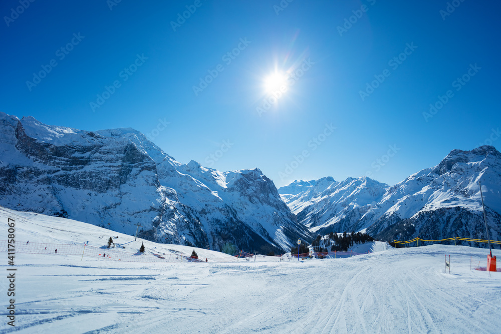 Mountain peaks and clean empty ski trails in Pralognan-la-Vanoise range over snowy tops in French Al