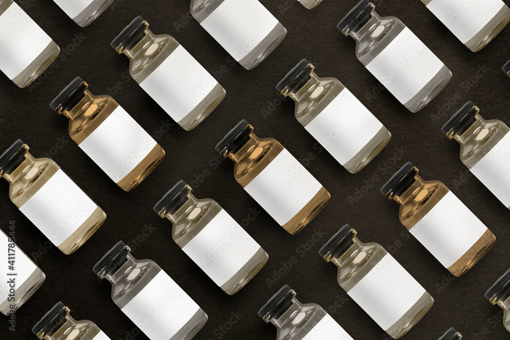 Vitamin injection glass bottles arranged in rows on black background