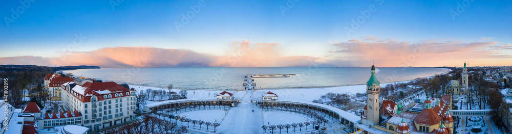 冬天，波兰索波特白雪皑皑的海滩和码头（莫罗）上美丽的日落