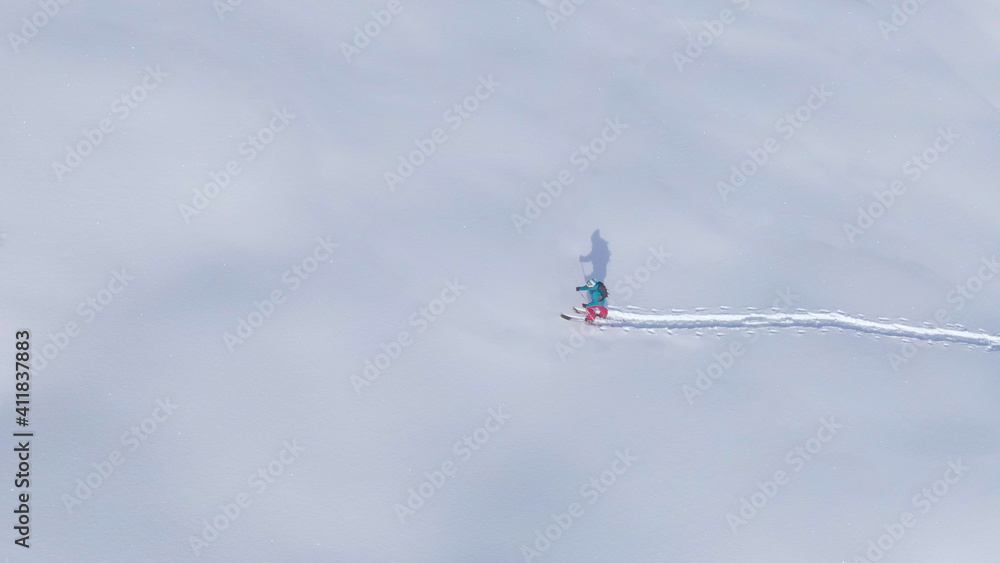 无人机：拍摄一名女性滑雪游客周围的冬季景观。